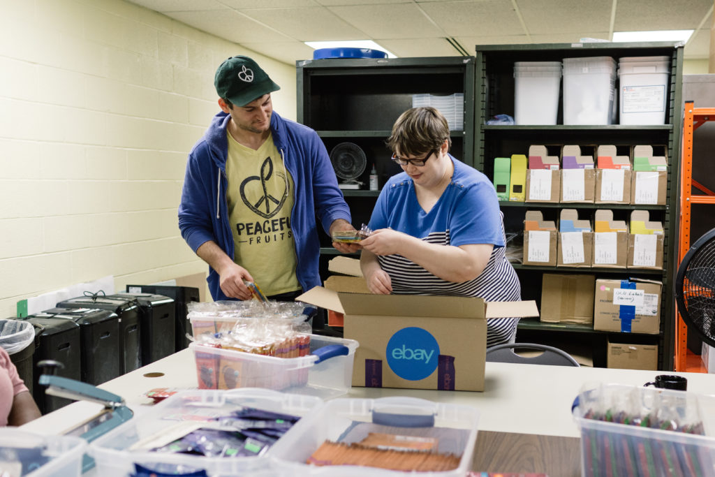 PHOTO: Evan packing an order with a Peaceful Fruits team member. 